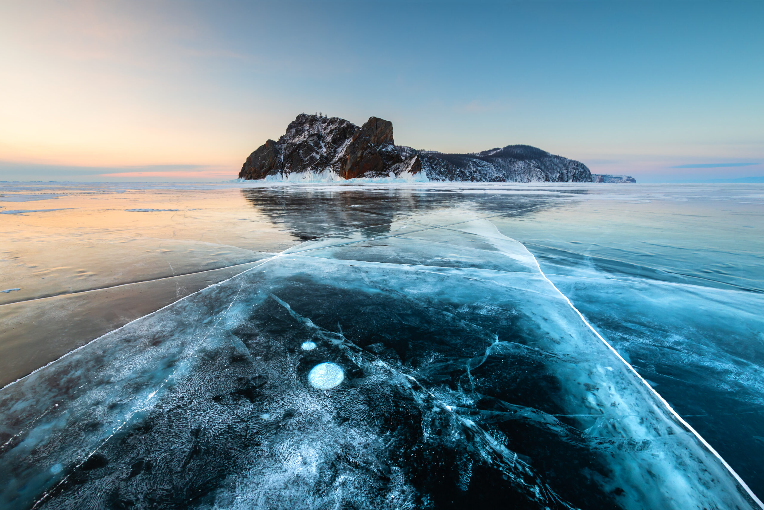 Blue cracked ice on Baikal lake in winter. Khoboy cape of Olkhon